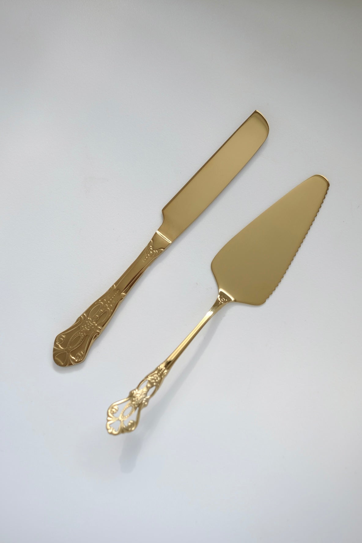 סט כף וסכין לעוגה וינטג׳ ציפוי זהב עם עיטורים קלאסיים בעיצוב יוקרתי ואלגנטי, סט 2 חלקים סכין וכף לחיתוך עוגה וינטגי בעיצוב ייחודי ויוקרתי ציפוי זהב תוצרת פולין מושלם להגשת עוגות באירועים ועיצוב שולחן חג. מוסיף תזכורת מתקופה הויקטוריאני ומביאות נגיעה של אלגנטיות ונוסטלגיה לעיצוב השולחן. סט הגשה לעוגה עשוי נרוסטה מצופה זהב, משדר קסם ותחכום של העולם הישן שמשתלב עם הפריטים המודרניים באופן נהדר. מתנות לאוהבי וינטג׳, מתנה לאירוח בלתי נשכח, מתנות יוקרה להבית, מתנות עם אופי ואישיות, רעיונות למתנות ייחודיות לחג, מתנ