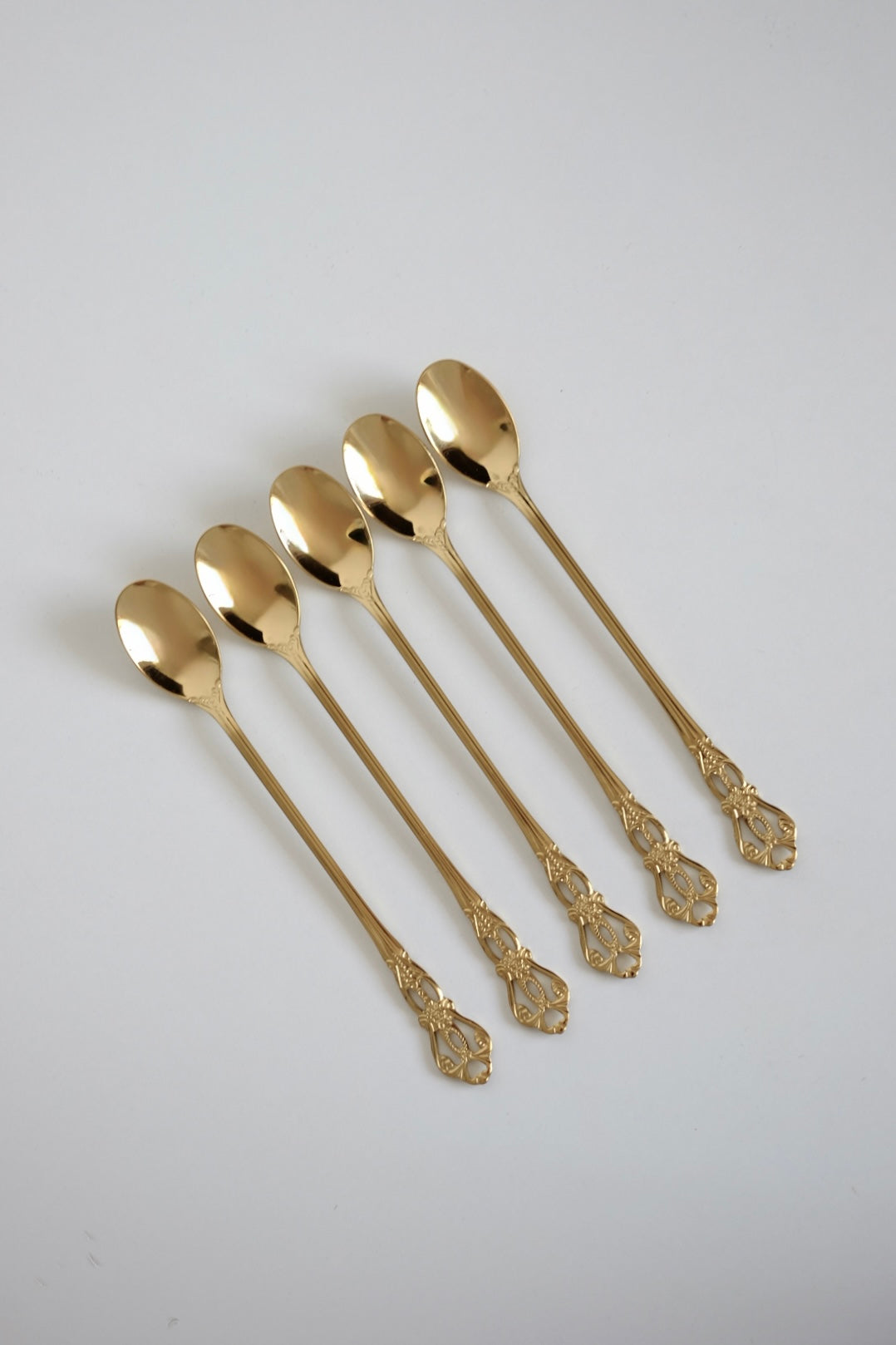 כפיות קוקטל ארוכות וינטג׳ סט של 5 כפיות ציפוי זהב עם חריטה דקורטיבית. סט של חמש כפיות בר וינטג׳ מנירוסטה ציפוי זהב. הן פריט נדיר לאוהבי מטבח בסטייל רטרו ופרטי וינטגי מיוחדים לבית. כפיות ארוכות הן כלי מטבח וינטג׳ יוקרטיים ומתאימות מושלם להגשת קינוח ועיצוב שולחן חג. הכפיות הן חלק מקולקציית כלי מטבח בסטייל ייחודי שלא רק משדרג מראה שולחן חגיגי, אלא גם מוסיף חווית ארוחה אירופאית אלגנטית של פעם. זאת מתנה נהדרת לאנשים שאוהבים פריטי אספנות נדירים ולמי שמעריך סטייל ואסתטיקה. כלי הגשה לפסח יוקרתיים, סט כלים לחג פסח ב