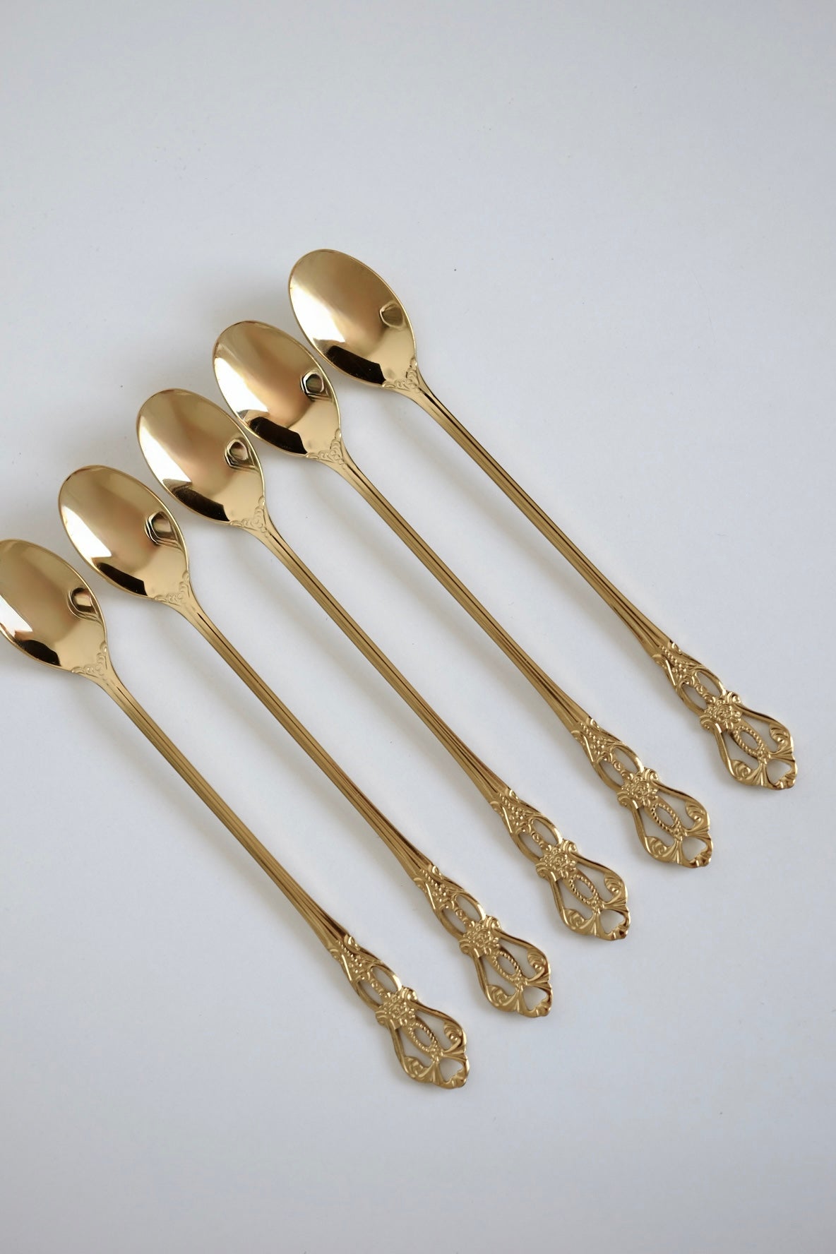 כפיות קוקטל ארוכות וינטג׳ סט של 5 כפיות ציפוי זהב עם חריטה דקורטיבית. סט של חמש כפיות בר וינטג׳ מנירוסטה ציפוי זהב. הן פריט נדיר לאוהבי מטבח בסטייל רטרו ופרטי וינטגי מיוחדים לבית. כפיות ארוכות הן כלי מטבח וינטג׳ יוקרטיים ומתאימות מושלם להגשת קינוח ועיצוב שולחן חג. הכפיות הן חלק מקולקציית כלי מטבח בסטייל ייחודי שלא רק משדרג מראה שולחן חגיגי, אלא גם מוסיף חווית ארוחה אירופאית אלגנטית של פעם. זאת מתנה נהדרת לאנשים שאוהבים פריטי אספנות נדירים ולמי שמעריך סטייל ואסתטיקה. כלי הגשה לפסח יוקרתיים, סט כלים לחג פסח ב