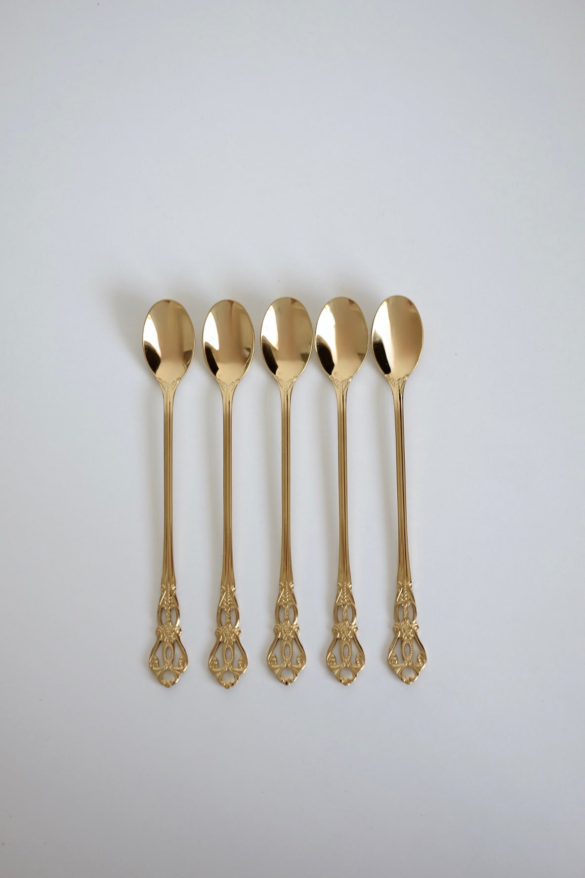 כפיות קוקטל ארוכות וינטג׳ סט של 5 כפיות ציפוי זהב עם חריטה דקורטיבית. סט של חמש כפיות בר וינטג׳ מנירוסטה ציפוי זהב. הן פריט נדיר לאוהבי מטבח בסטייל רטרו ופרטי וינטגי מיוחדים לבית. כפיות ארוכות הן כלי מטבח וינטג׳ יוקרטיים ומתאימות מושלם להגשת קינוח ועיצוב שולחן חג. הכפיות הן חלק מקולקציית כלי מטבח בסטייל ייחודי שלא רק משדרג מראה שולחן חגיגי, אלא גם מוסיף חווית ארוחה אירופאית אלגנטית של פעם. זאת מתנה נהדרת לאנשים שאוהבים פריטי אספנות נדירים ולמי שמעריך סטייל ואסתטיקה. כלי הגשה לפסח יוקרתיים, סט כלים לחג פסח ב